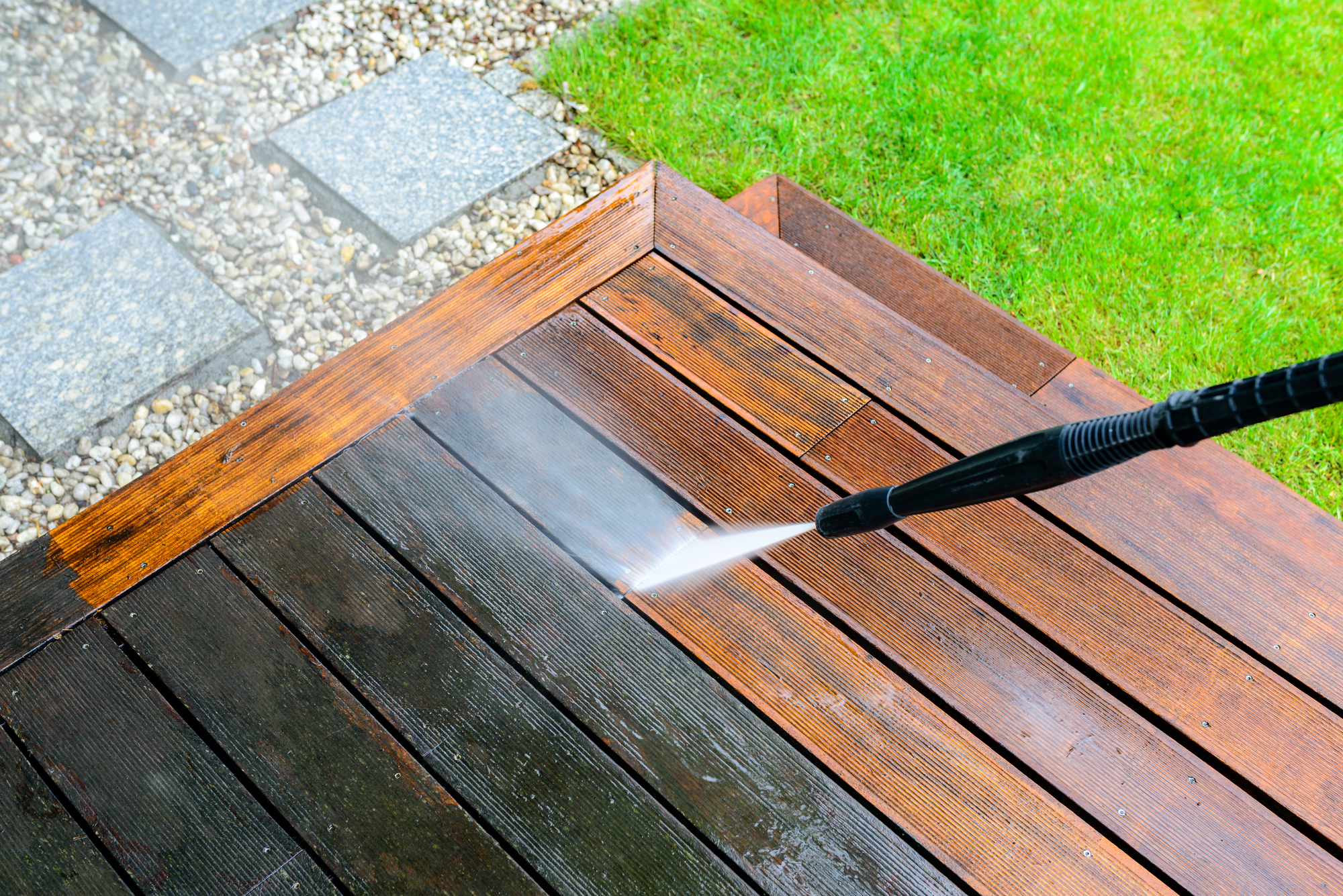 cleaning terrace with a power washer - high water pressure cleaner on wooden terrace surface